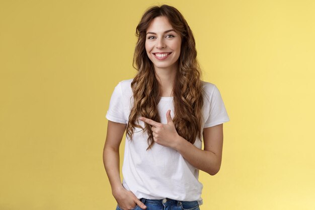 Portrait of smiling young woman against yellow background