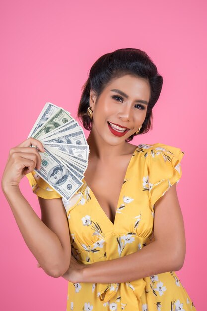 Portrait of smiling young woman against yellow background