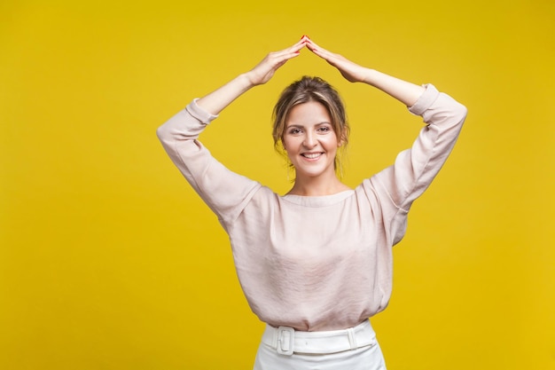 Foto ritratto di una giovane donna sorridente su uno sfondo giallo