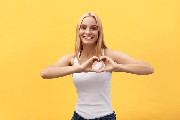 Portrait of a smiling young woman against yellow background