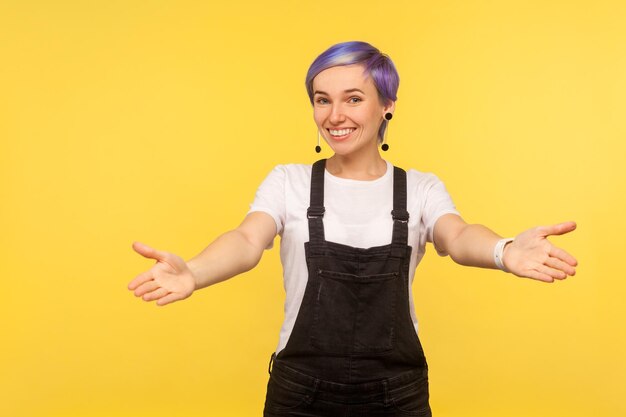 Photo portrait of a smiling young woman against yellow background