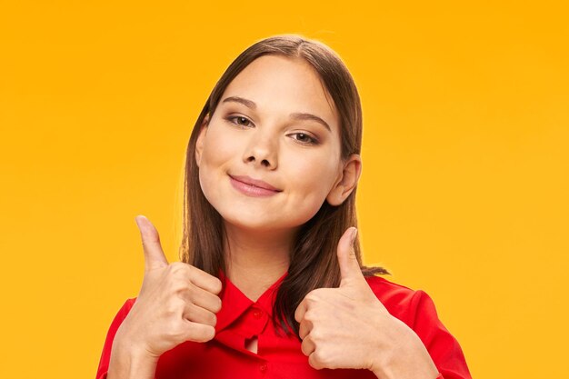 Portrait of smiling young woman against yellow background