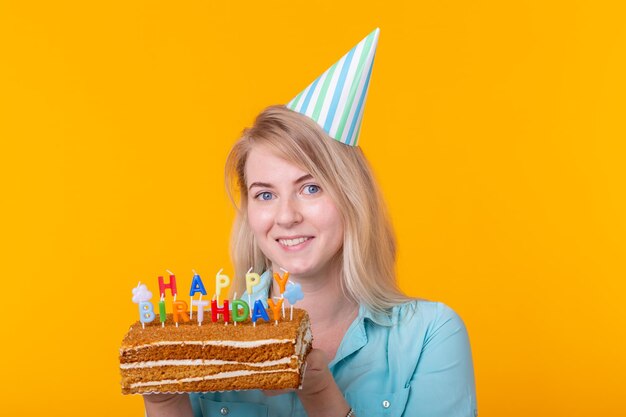 Portrait of smiling young woman against yellow background