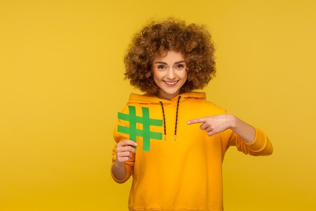 Portrait of a smiling young woman against yellow background