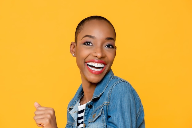 Portrait of a smiling young woman against yellow background