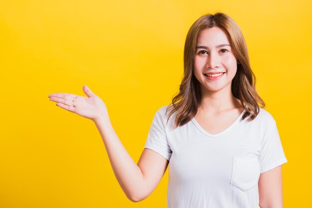 Portrait of a smiling young woman against yellow background