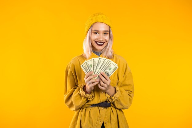 Portrait of a smiling young woman against yellow background