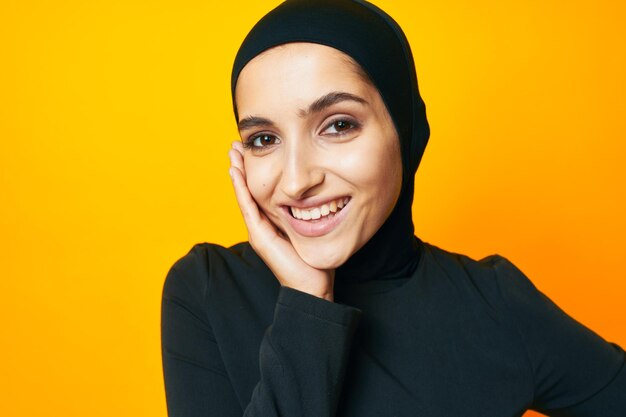 Portrait of a smiling young woman against yellow background