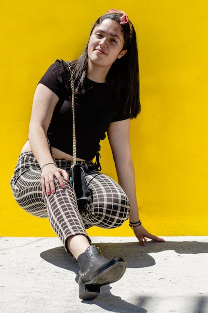 Photo portrait of smiling young woman against yellow wall