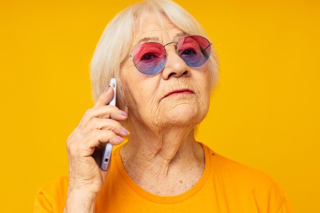 Portrait of smiling young woman applying make-up against yellow background