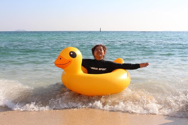 Foto ritratto di una giovane donna sorridente sulla spiaggia contro il cielo