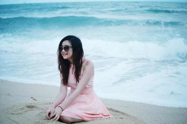 Photo 해변 에서 미소 짓는 젊은 여자 의 초상화