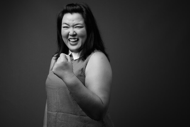 Photo portrait of a smiling young woman over black background