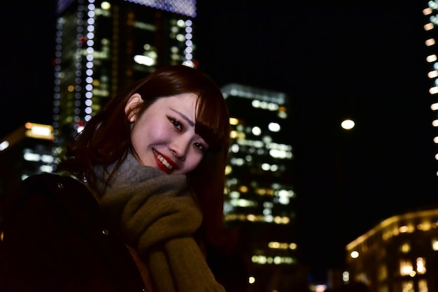 Photo portrait of smiling young woman in city at night