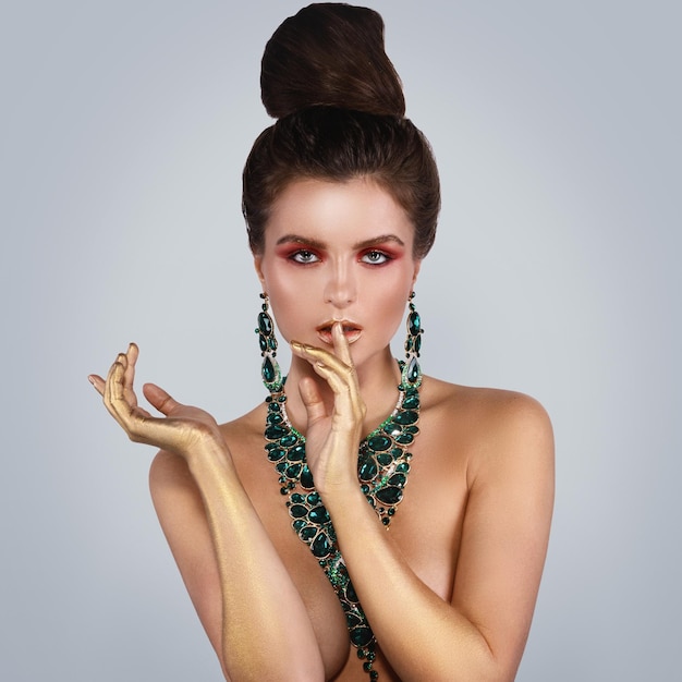 Portrait of smiling young woman drinking water against white background