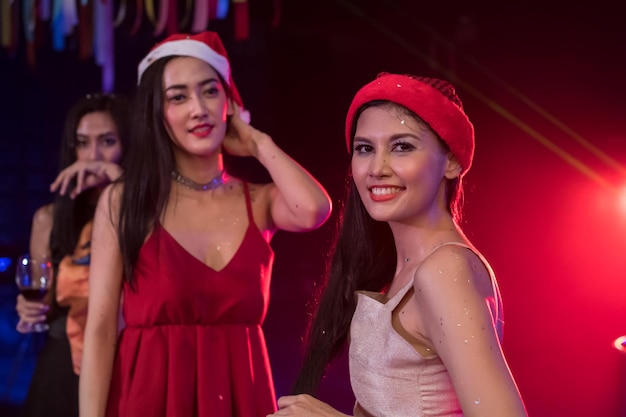 Photo portrait of smiling young woman enjoying with friend at nightclub