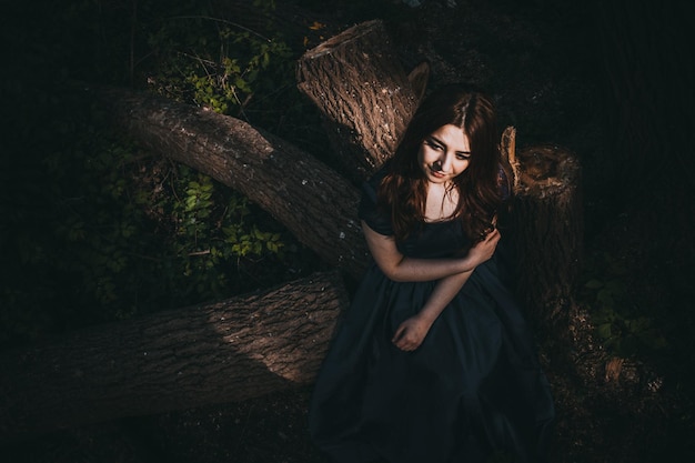 Photo portrait of smiling young woman in forest at night