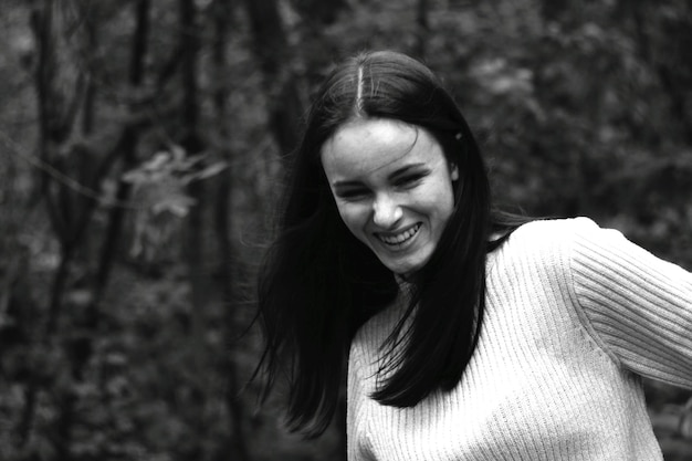 portrait of smiling young woman in forest
