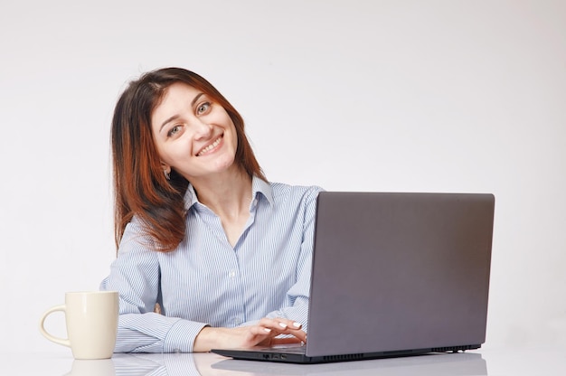 Portrait of a smiling young woman in front of the computer