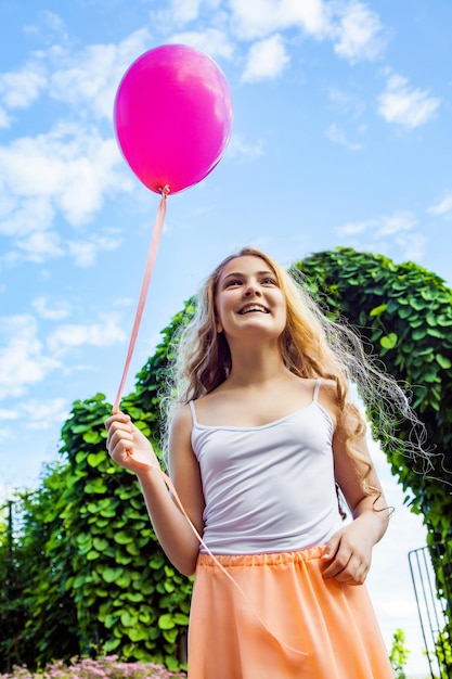 Photo portrait of a smiling young woman holding balloons