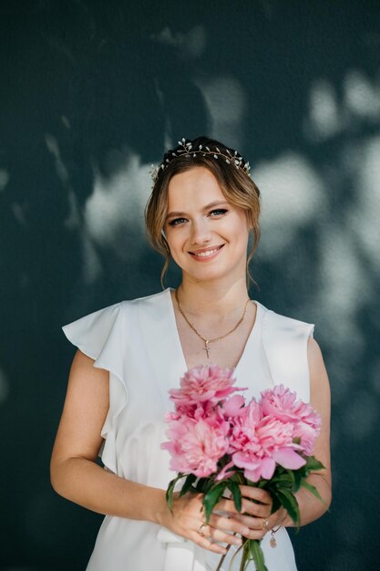 Portrait of a smiling young woman holding a bouquet of peony