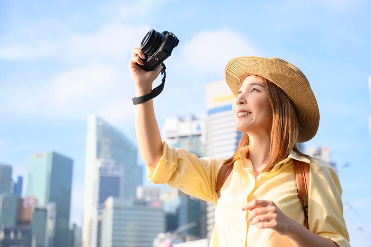Photo 空に向かってカメラを握っている笑顔の若い女性の肖像画