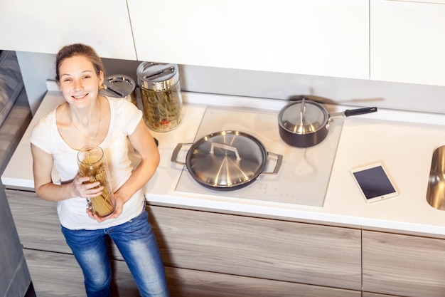 Photo portrait of a smiling young woman holding camera at home