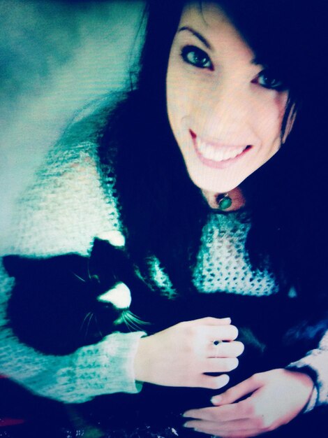 Photo portrait of smiling young woman holding cat