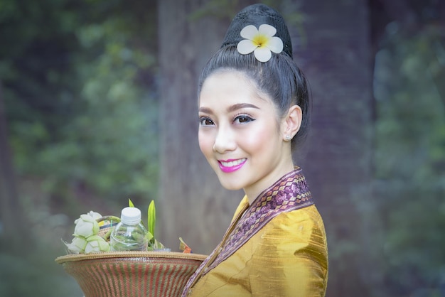 Photo portrait of a smiling young woman holding flowering plant