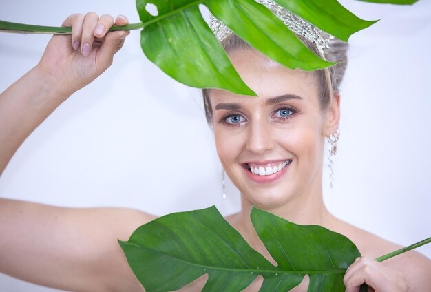 Foto ritratto di una giovane donna sorridente che tiene le foglie
