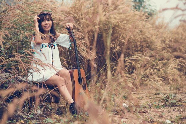 Photo portrait of smiling young woman holding plant on land