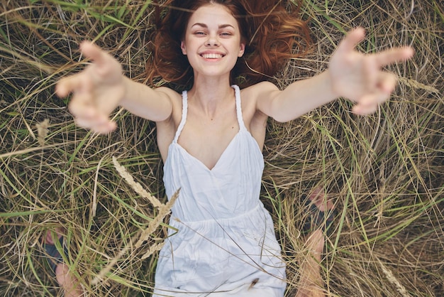 Foto ritratto di una giovane donna sorridente sdraiata sul campo