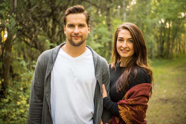 Photo portrait of smiling young woman and man in forest