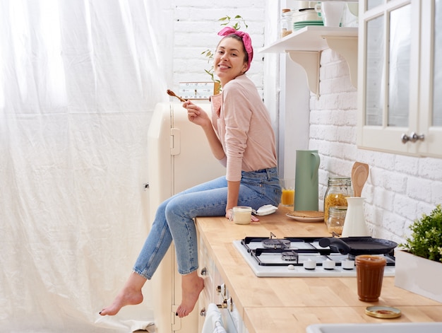 Ritratto di giovane donna sorridente in cucina moderna