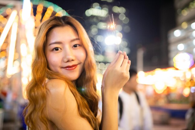 Photo portrait of smiling young woman at night