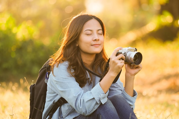 Photo portrait of smiling young woman photographing outdoors