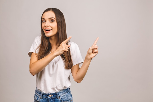 Portrait of smiling young woman pointing finger up