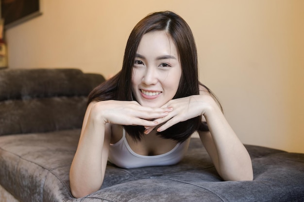 Portrait of smiling young woman relaxing on bed