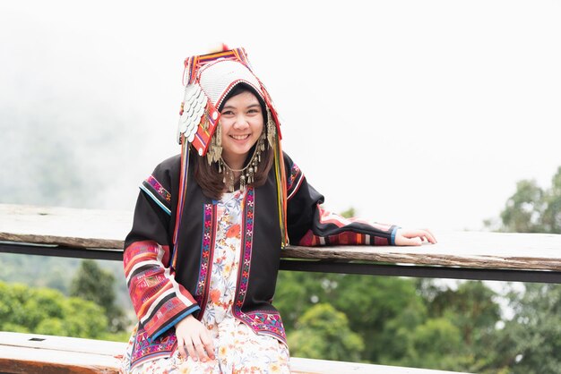 Foto ritratto di una giovane donna sorridente seduta contro un cielo limpido