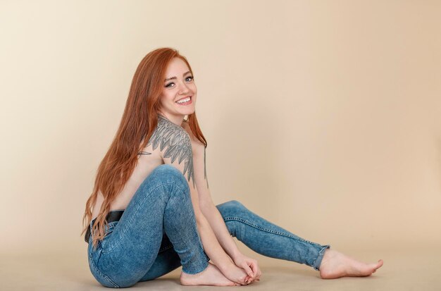 Portrait of smiling young woman sitting against wall