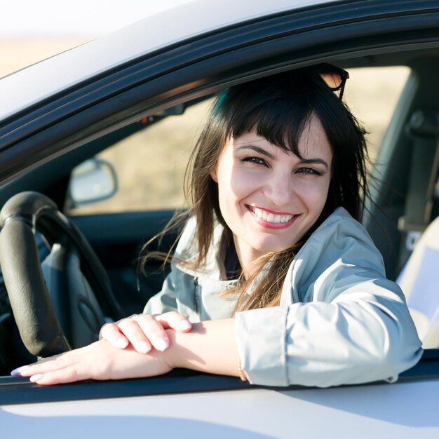 車に座っている笑顔の若い女性の肖像画