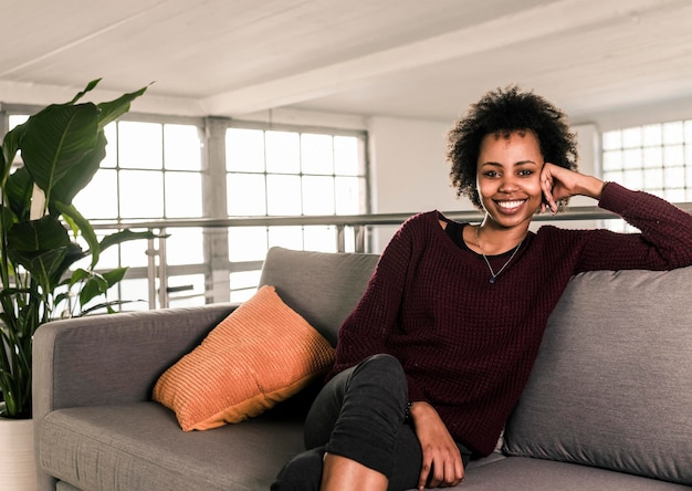 Portrait of smiling young woman sitting on couch