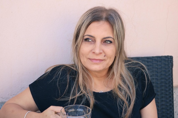 Photo portrait of smiling young woman sitting at home