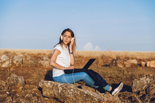 Photo portrait of smiling young woman sitting on land