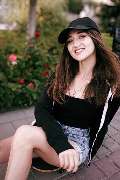 Photo portrait of smiling young woman sitting outdoors