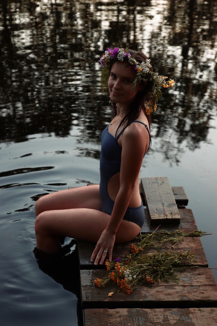 Photo portrait of smiling young woman sitting on pier in lake