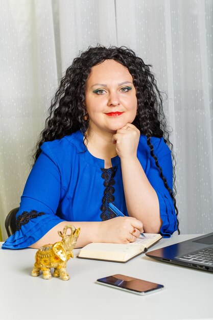 Portrait of a smiling young woman sitting on table