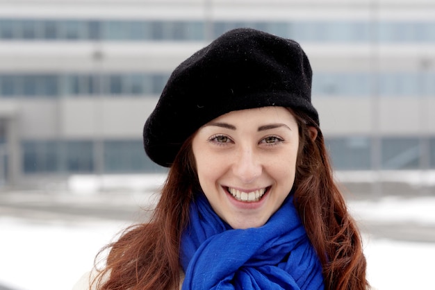 Foto ritratto di una giovane donna sorridente nella neve