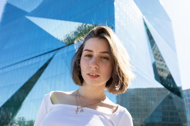 Portrait of smiling young woman standing against building