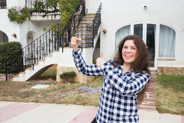 Photo portrait of smiling young woman standing against building